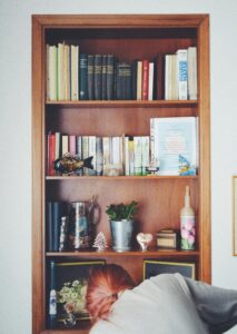 Woman cleaning cabinte with books